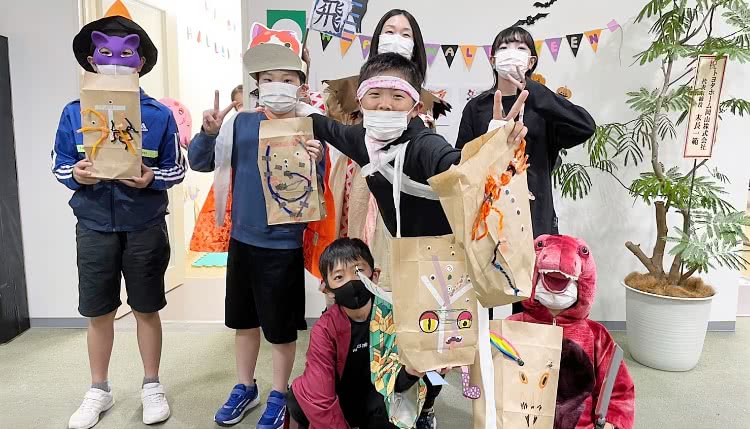 仮装した子どもと先生たちの集合写真
